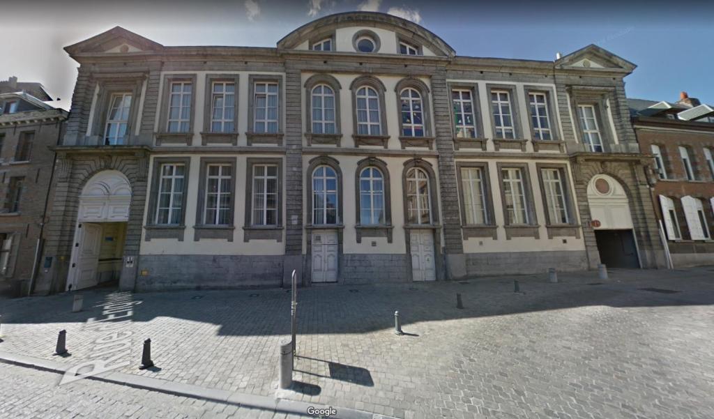 un grande edificio con molte finestre di Logement dans le cœur historique de Mons a Mons