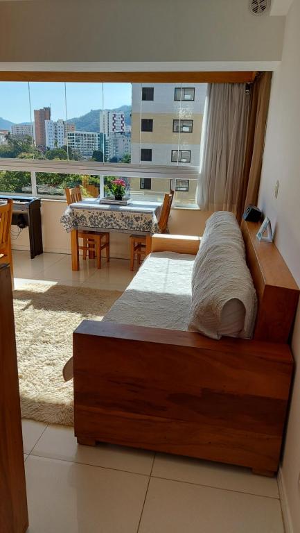 um quarto com uma cama grande e uma mesa com cadeiras em Cosy Apartment in Fantastic Location in City Center em Poços de Caldas