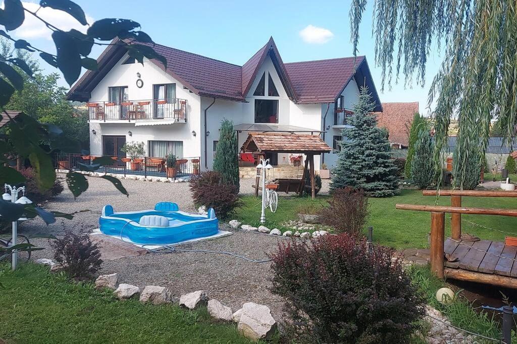 ein Haus mit einer blauen Badewanne vor einem Hof in der Unterkunft Casa Nicholas in Zărneşti
