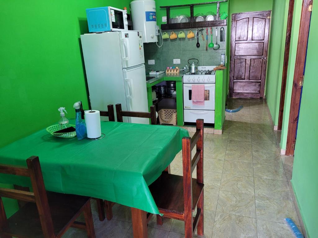 cocina verde con mesa y nevera en El RINCON de ROSA 1, en Mar del Tuyú