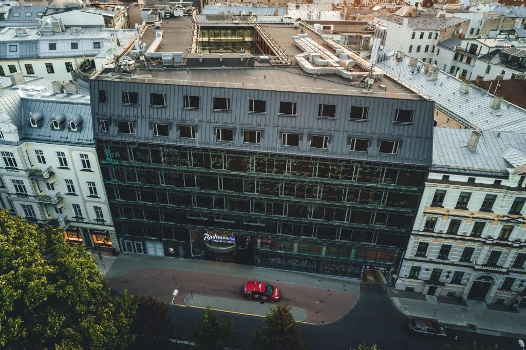 un bâtiment en construction avec une voiture rouge dans une rue dans l'établissement Radisson Blu Elizabete Hotel, Riga, à Riga