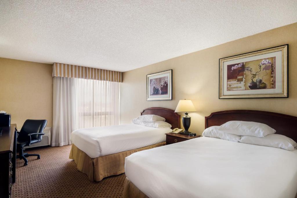 a hotel room with two beds and a desk at Red Lion Hotel Cheyenne in Cheyenne