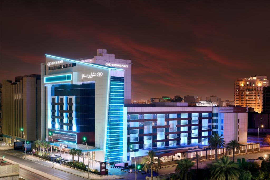 فندق كراون بلازا رياض منهال في الرياض: مبنى كبير به أضواء زرقاء في مدينة في الليل