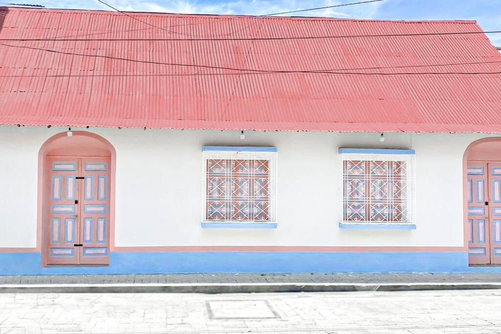 a white and red building with a red roof at Casa Ultra Moderna El Corazón De Flores in Flores
