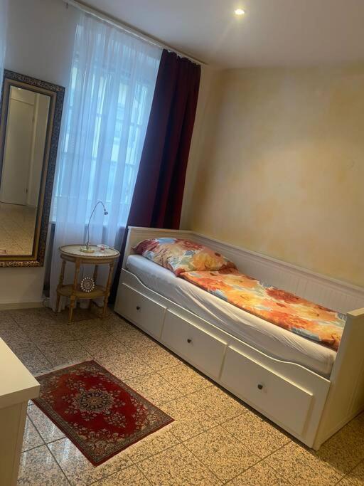 1 dormitorio con cama, ventana y espejo en Schöne und Gemütliche Wohnung in Trier Zentrum, en Trier