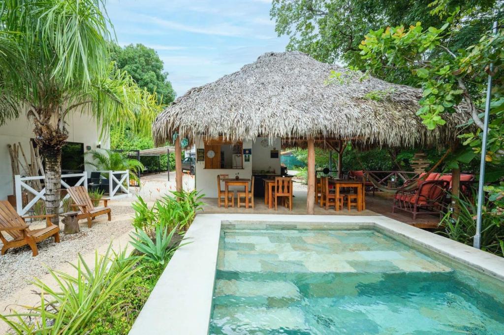 タマリンドにあるAntema Lodge Secteur Tamarindo, piscine, yoga, gym, jungle et paixのスイミングプールと小屋付きのヴィラ