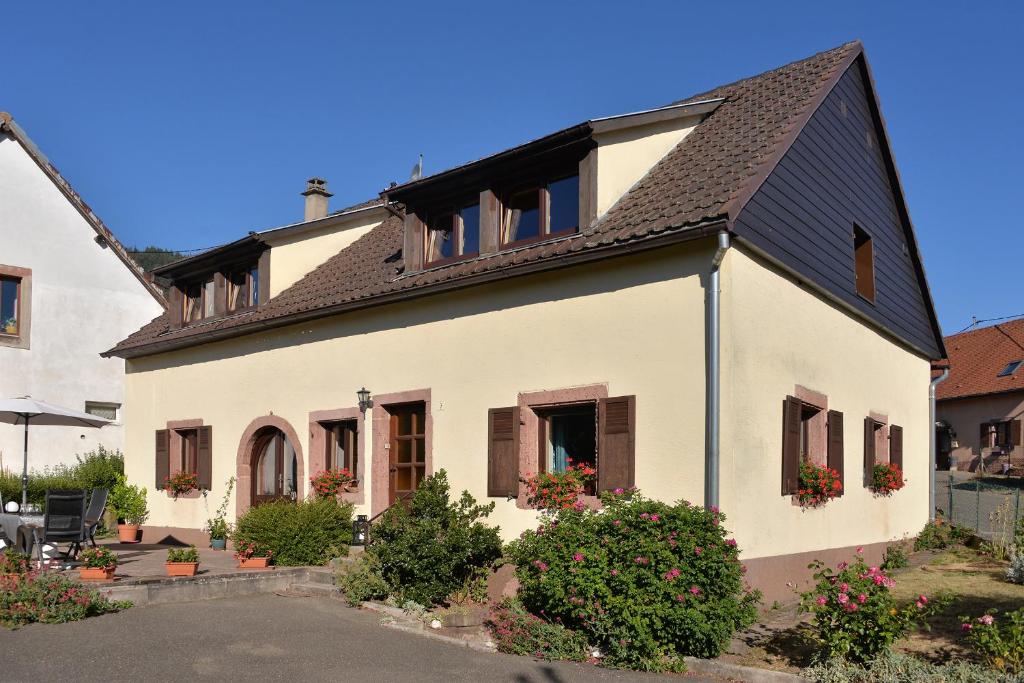 ein weißes Haus mit schwarzem Dach in der Unterkunft AU GRE DES SAISONS in Thannenkirch
