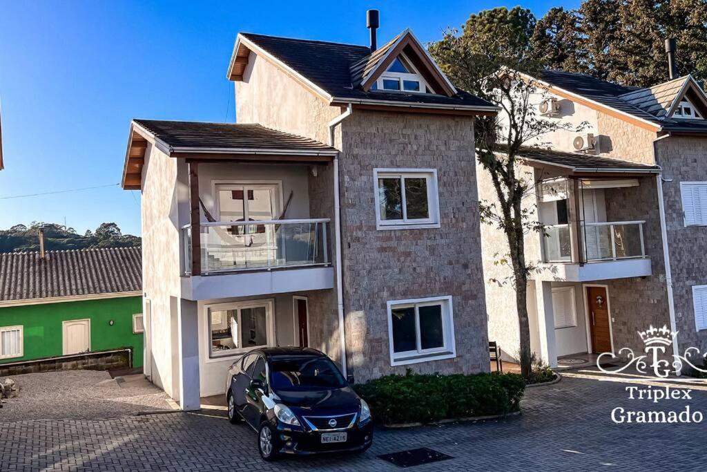 um carro estacionado em frente a uma casa em Casa Triplex com 03 Suítes, Cond no Centro Gramado em Gramado