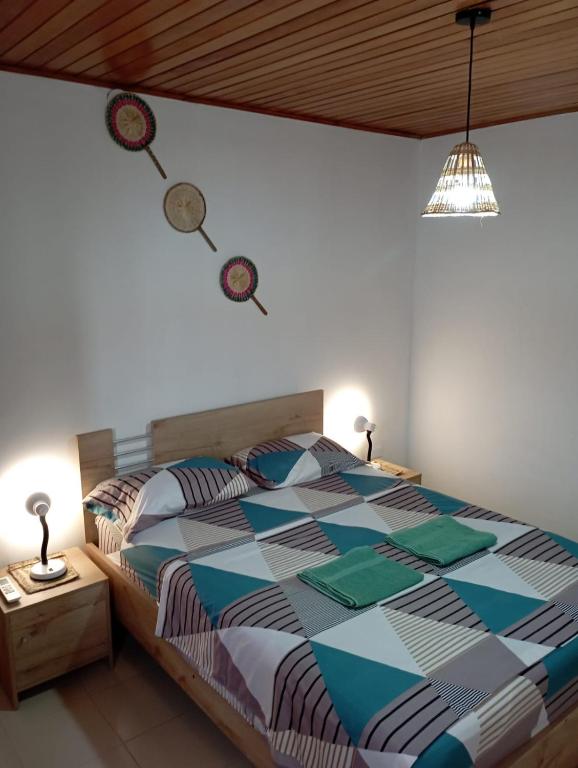 a bedroom with a bed with a colorful comforter at Apartamento Hogar Caribeño 2H con AA in Santa Marta