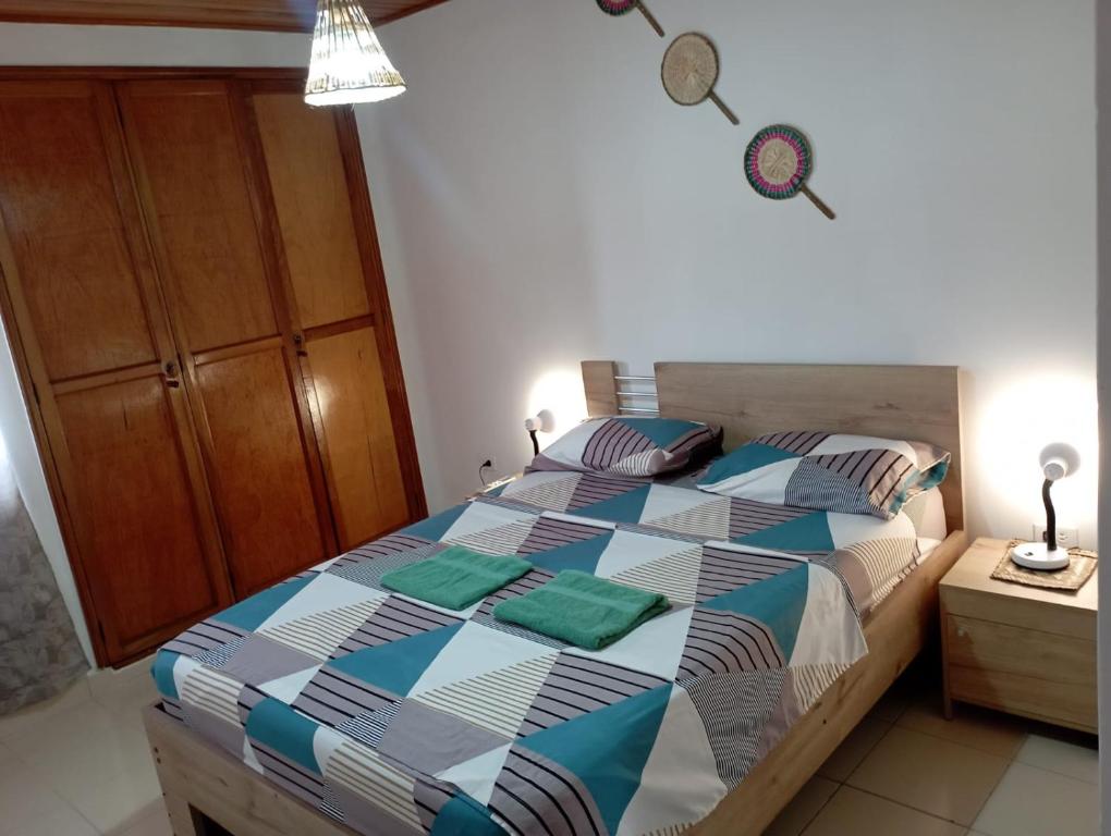 ein Schlafzimmer mit einem Bett mit einer bunten Bettdecke in der Unterkunft Apartamento Hogar Caribeño 2H con AA in Santa Marta