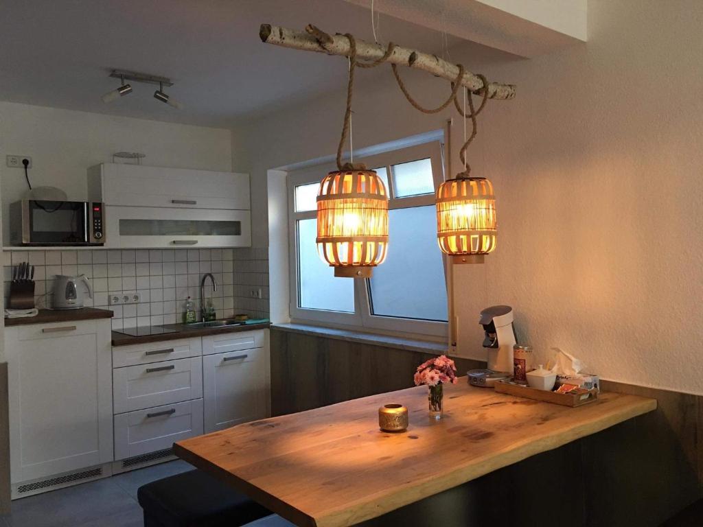 una cocina con 2 luces colgadas sobre una mesa de madera en FeWo Khuki, en Leipzig
