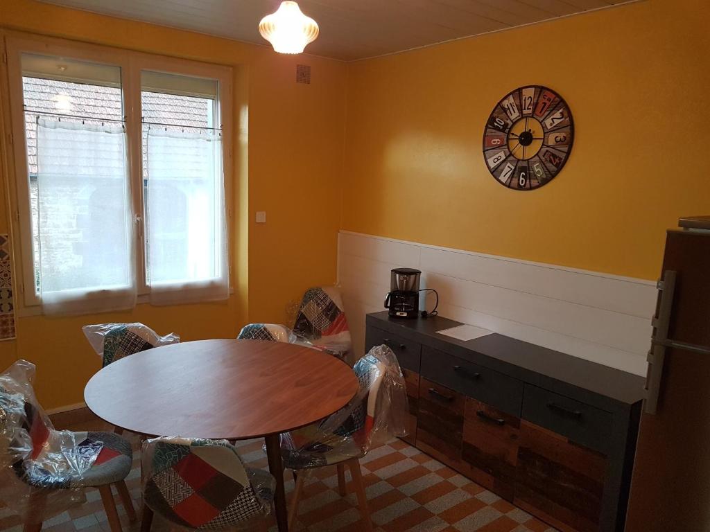 une salle à manger avec une table et une horloge au mur dans l'établissement Gite La maison d'Odette, à Saint-Georges-de-Mons