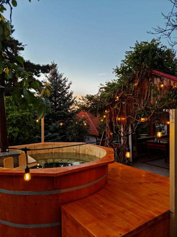 a jacuzzi tub on a deck with lights at Vila cu Ciubar & Jacuzzi - Sunset Hill House in Cuvin