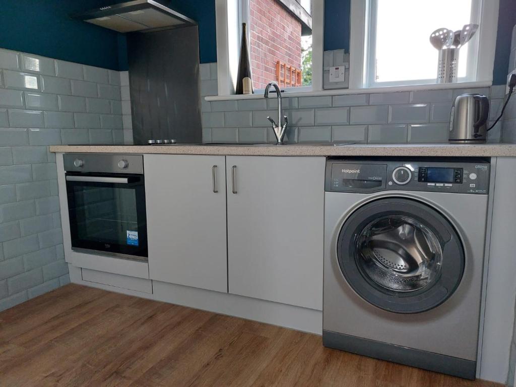 een keuken met een wasmachine en een wastafel bij spacious self-contained accommodation 135 cantebury road in Kent