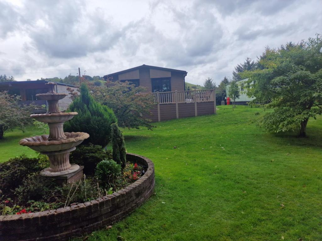 un giardino con fontana in mezzo a un cortile di Derwen 2 Bedroom Luxury Lodge a Welshpool