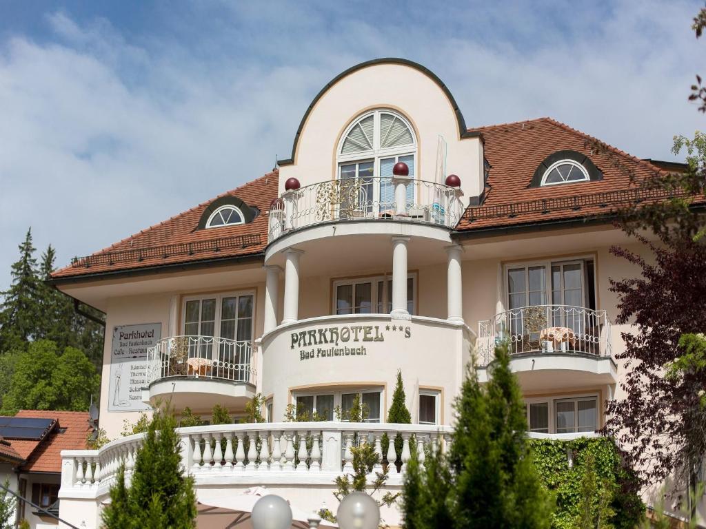 Großes weißes Haus mit Balkon in der Unterkunft Parkhotel Bad Faulenbach in Füssen