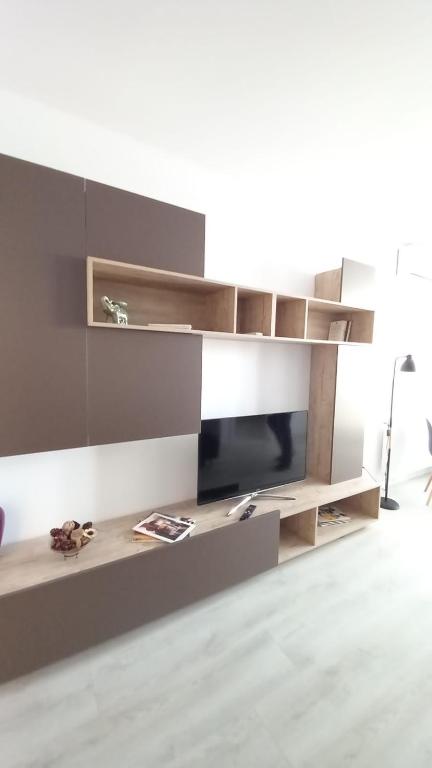 a living room with a tv and a shelf at Lovely Sunrise in Bucharest
