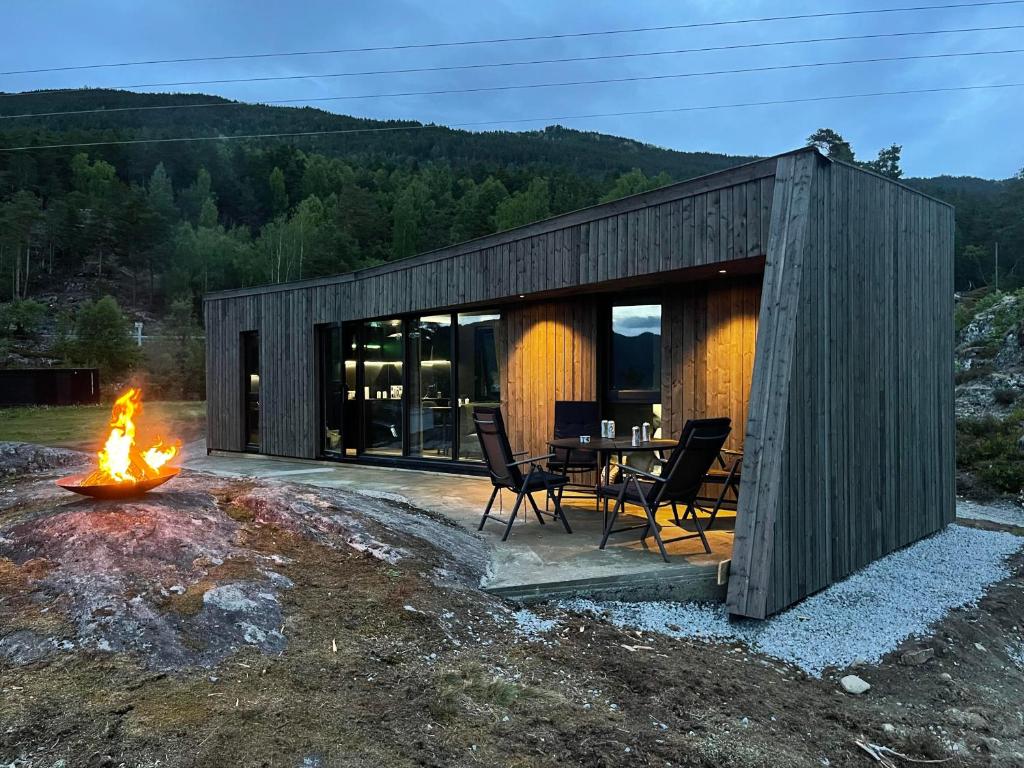 a wooden cabin with a table and chairs and a fire at Sogndal Fjordpanorama in Sogndal