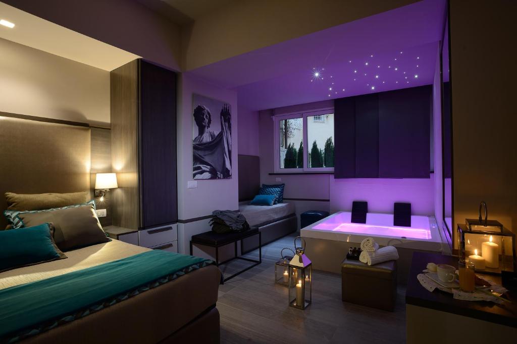 羅馬的住宿－聖卡羅套房酒店，一间卧室配有紫色照明、一张床和一张沙发