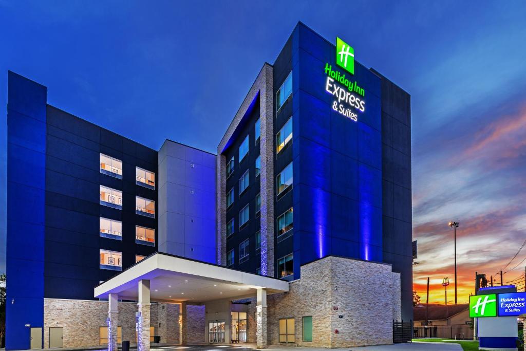 Holiday Inn Express & Suites - Houston - N Downtown, an IHG Hotel في هيوستن: مبنى الفندق مع وضع لافته عليه