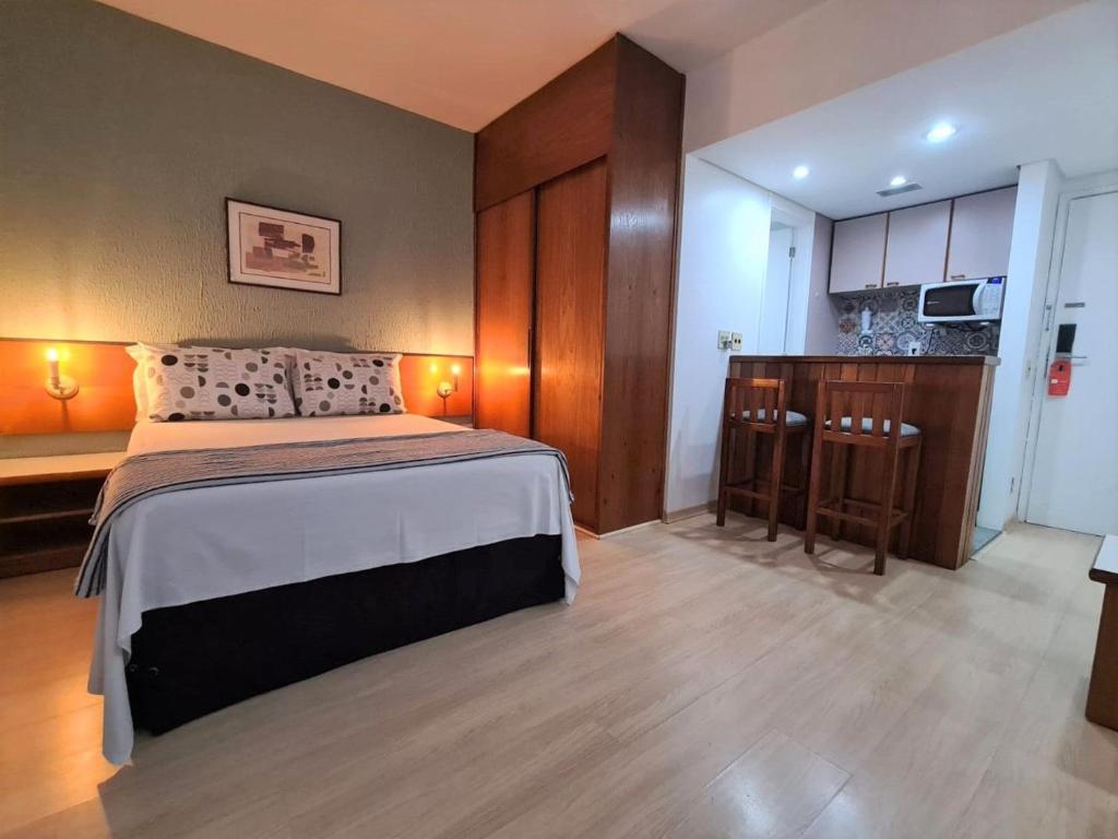 1 dormitorio con 1 cama grande y cocina en Qi Ibirapuera Intelligence Flat internet fibra e limpeza UH1903 en São Paulo