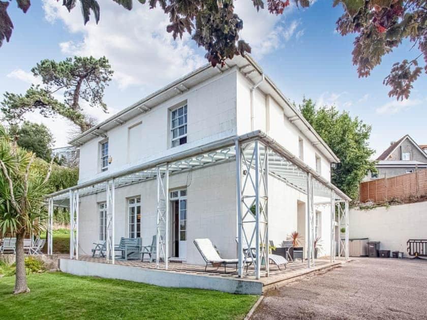 a white house with a conservatory on the front of it at Glenthorne Villa Torquay in Torquay