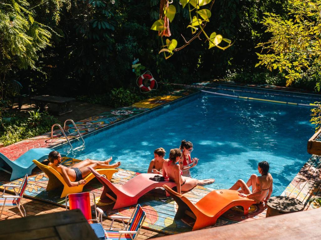 un groupe de personnes assises dans une piscine dans l'établissement Hostel Da Vila Ilhabela, à Ilhabela