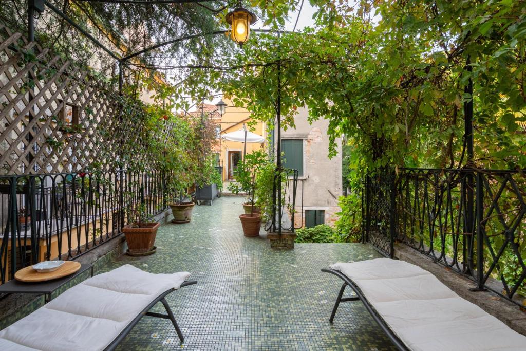 eine Außenterrasse mit Stühlen und einer Pergola in der Unterkunft Angelo Raffaele incantevole casa per 12 persone in Venedig