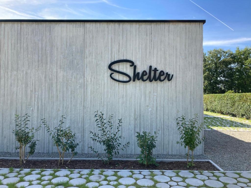 una señal de dirección en el lateral de un edificio en Shelter, en Zutendaal