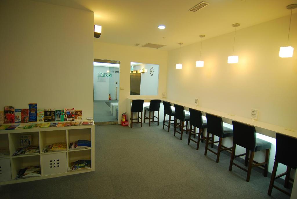 a waiting room with a row of chairs and a counter at Inn Cube - Ximen in Taipei