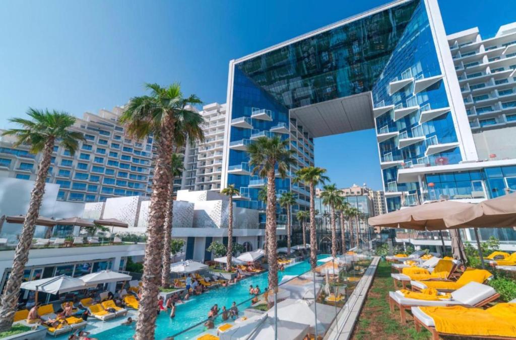 un complejo con piscina, palmeras y un edificio en Five Palm Jumeirah Suites-Sea View en Dubái