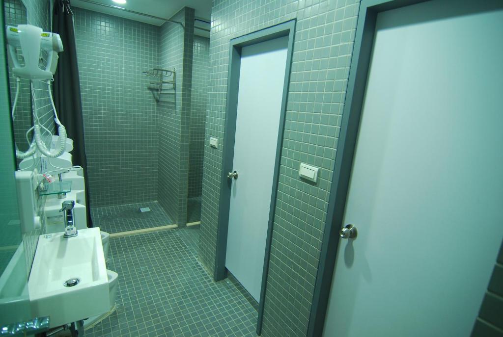 a bathroom with a shower and a sink and a mirror at Inn Cube - Ximen in Taipei