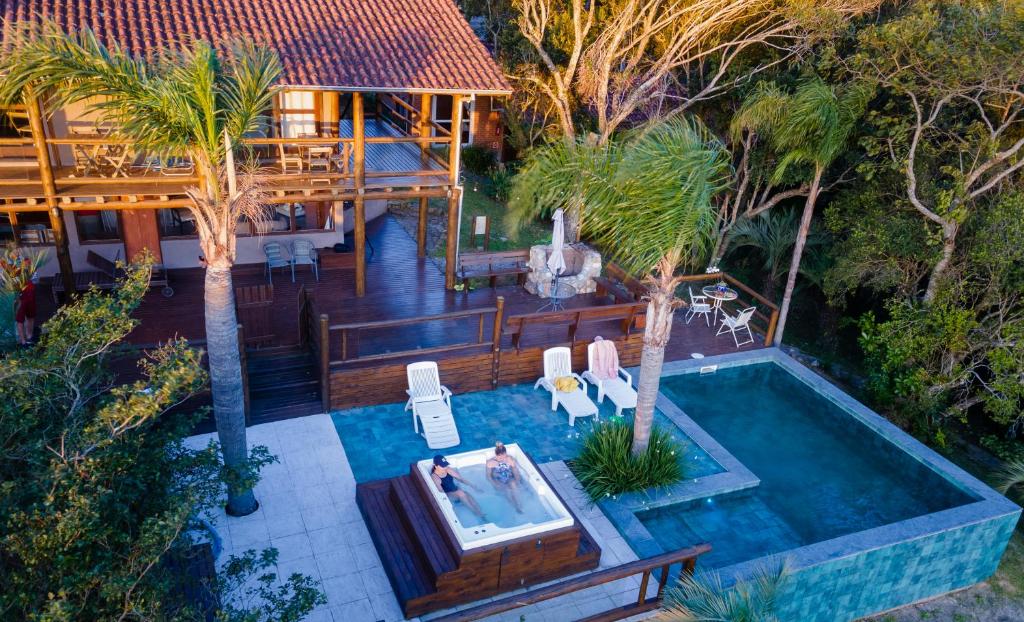 uma vista aérea de uma piscina com uma casa em Pousada Paraíso do Luz em Barra de Ibiraquera