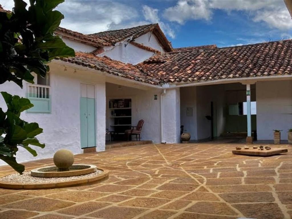 a house with a stone patio in front of it at La Nube Posada in Barichara