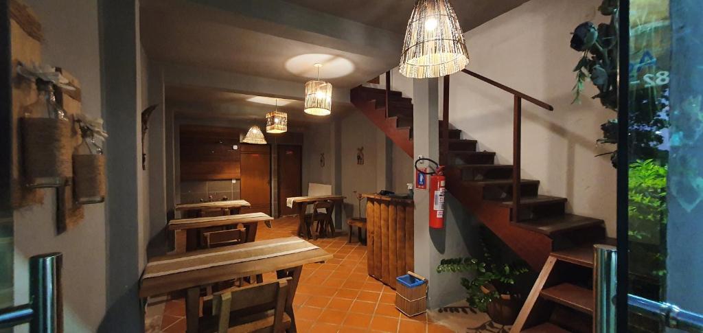 a restaurant with a staircase and benches and tables at Pousada Farol do Patacho in Pôrto de Pedras