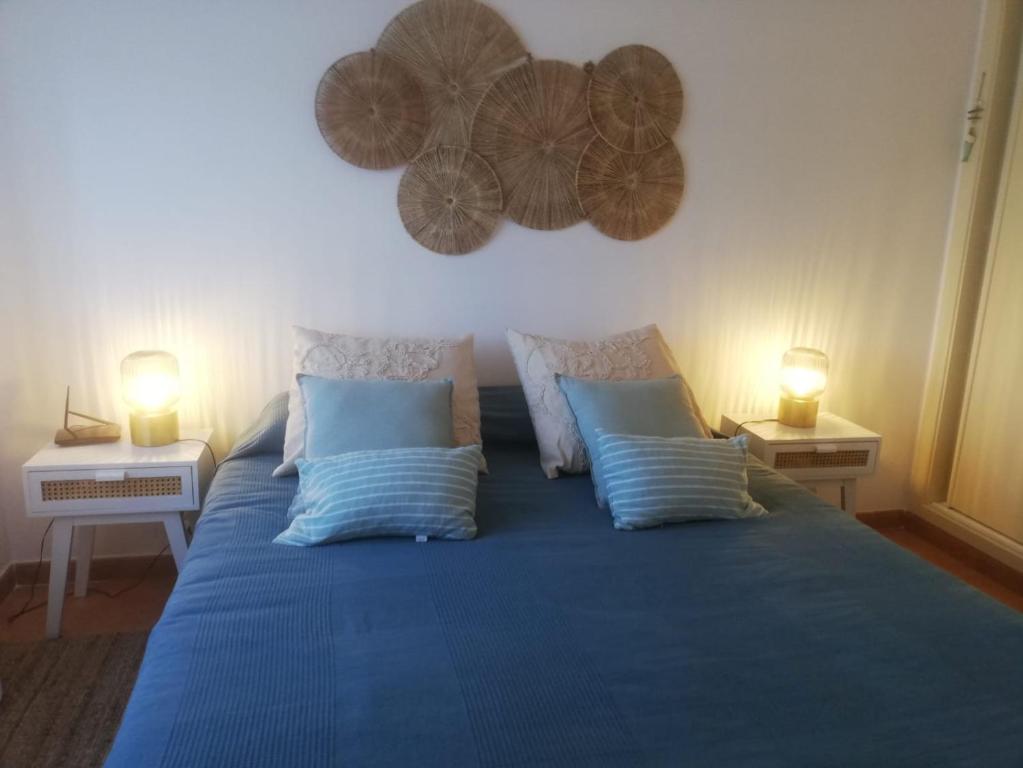 a bedroom with a blue bed with two lamps at Cabanas Acqua Golden in Cabanas de Tavira