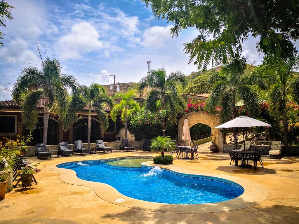 a swimming pool in a yard with tables and chairs at Casas del Toro Playa Flamingo in Playa Flamingo