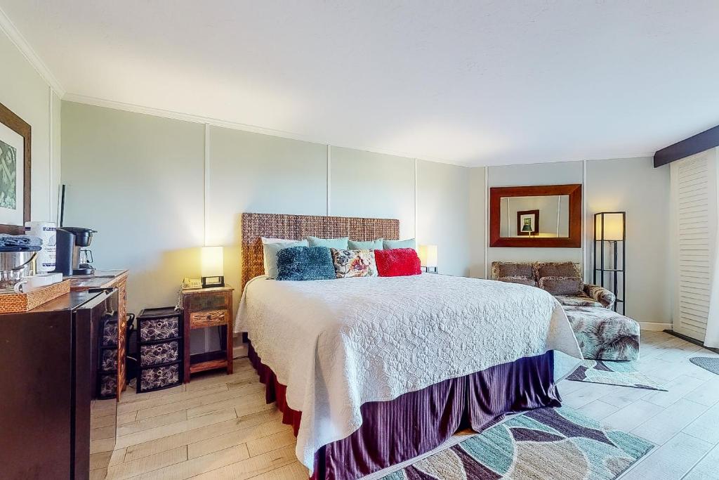 um quarto com uma cama grande e almofadas coloridas em Kauai Beach Resort #3124 em Lihue