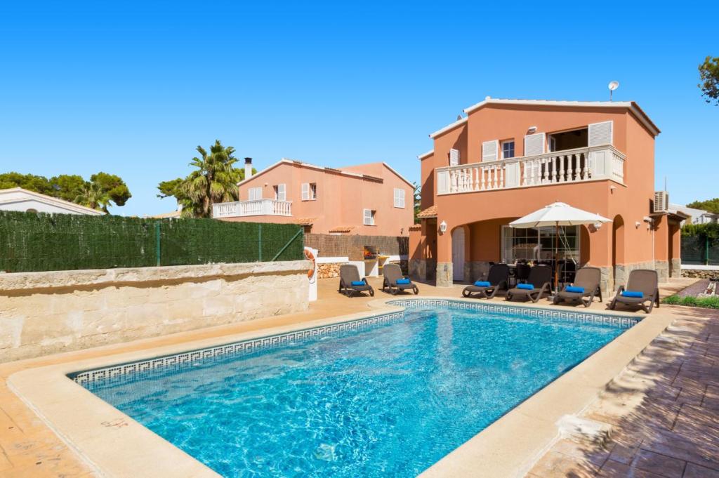 a villa with a swimming pool in front of a house at Villa Martinur by Villa Plus in Cala en Blanes