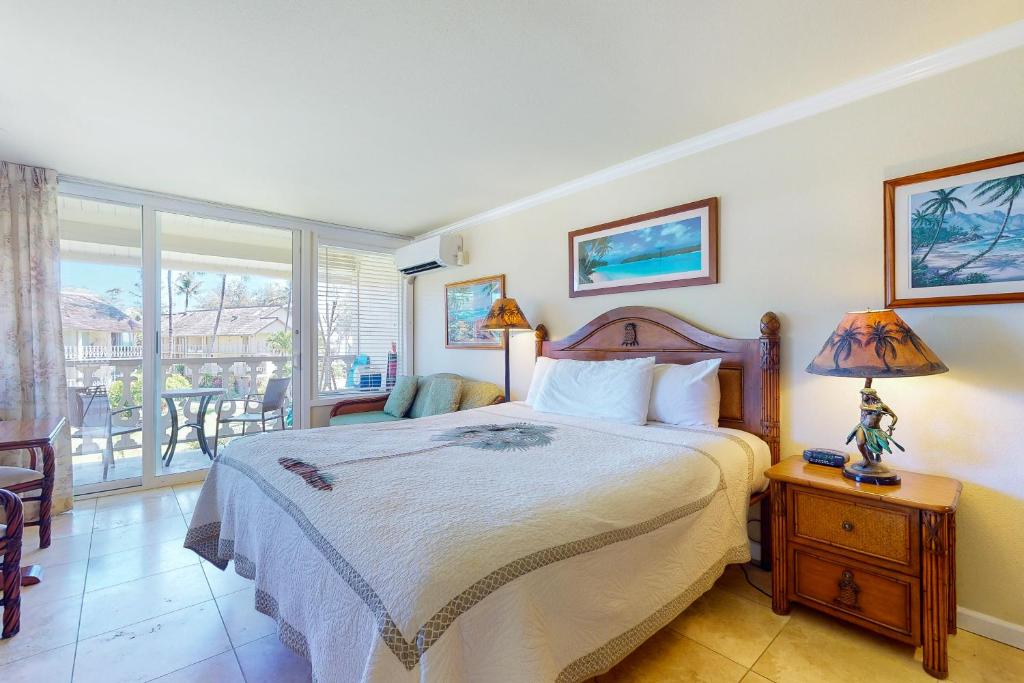 a bedroom with a large bed and a balcony at Islander on the Beach 339 in Kapaa
