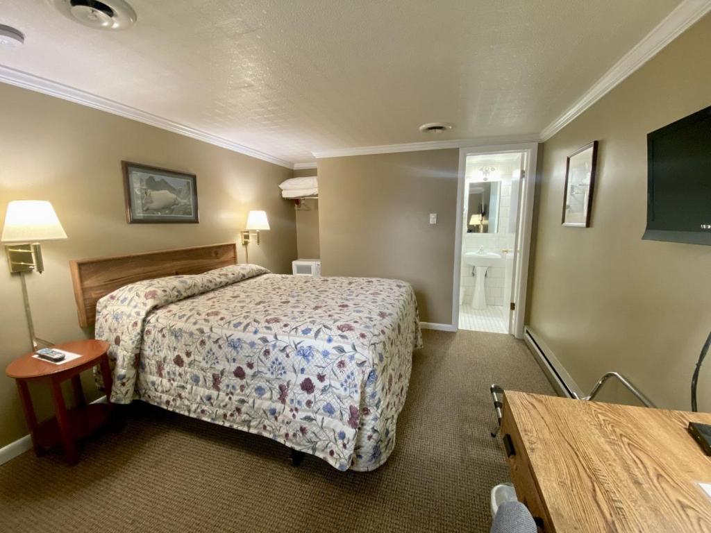 a hotel room with a bed and a table at Greybull Motel in Greybull