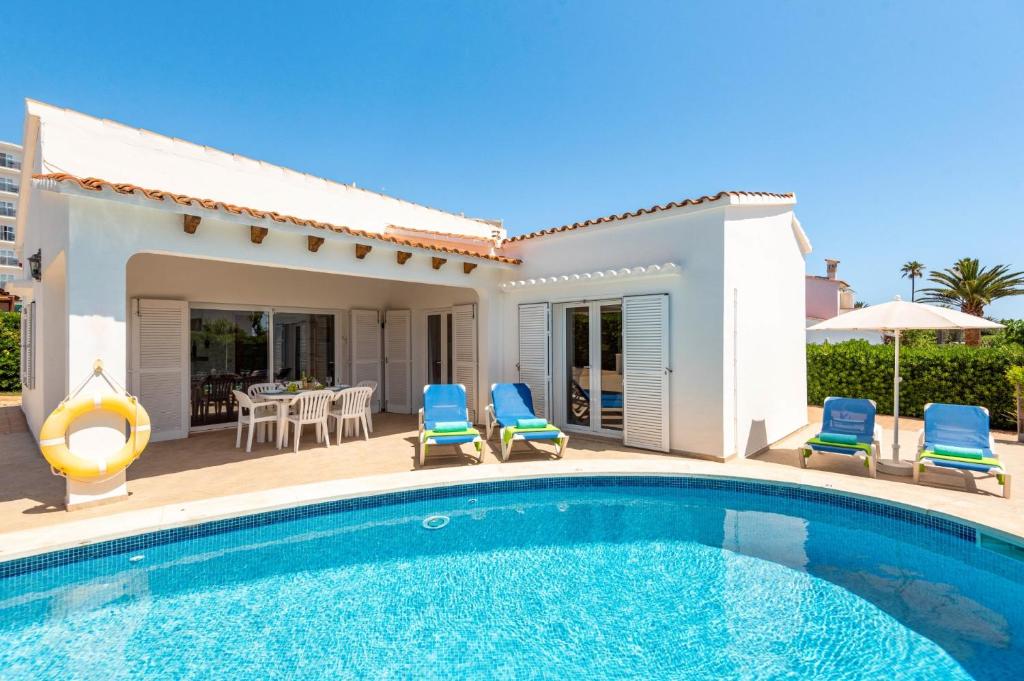 eine Villa mit einem Pool vor einem Haus in der Unterkunft Villa Mencia by Villa Plus in S'Algar