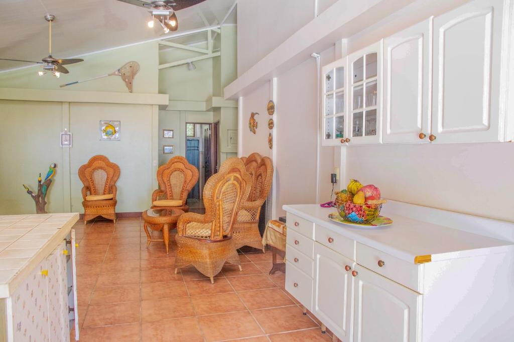 eine Küche mit weißen Schränken und Stühlen sowie einem Tisch in der Unterkunft Sunset House in Tivives