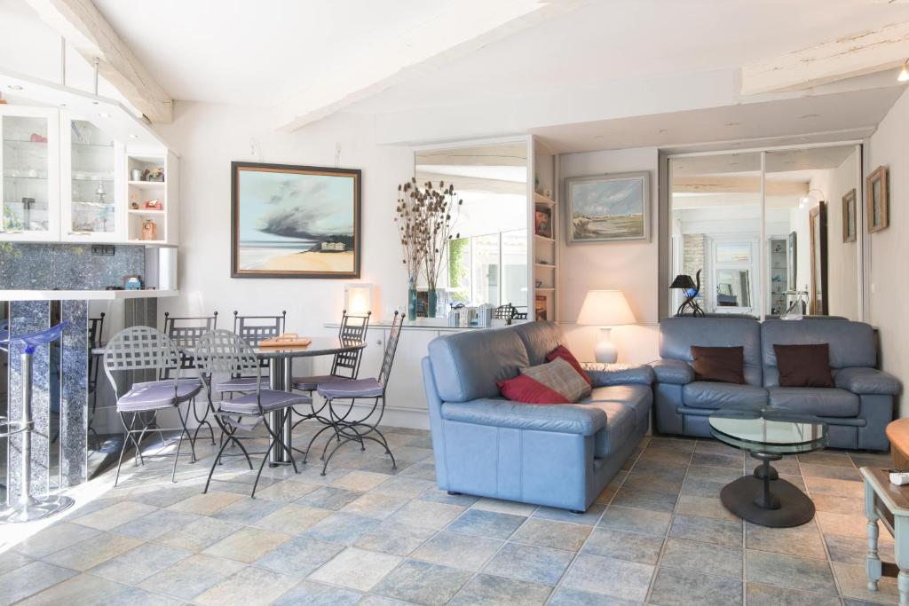a living room with a couch and a table and chairs at Maison typique &quot;Etrille&quot; proche du marché et de la plage in La Couarde-sur-Mer