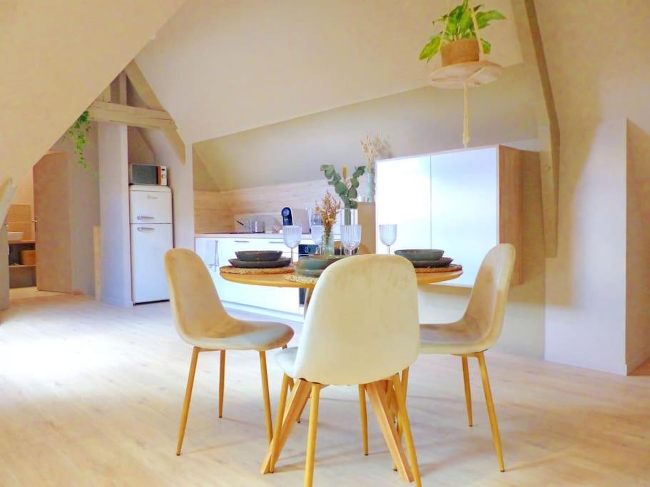 uma cozinha com mesa e cadeiras num quarto em Le Green Cosy em Évreux