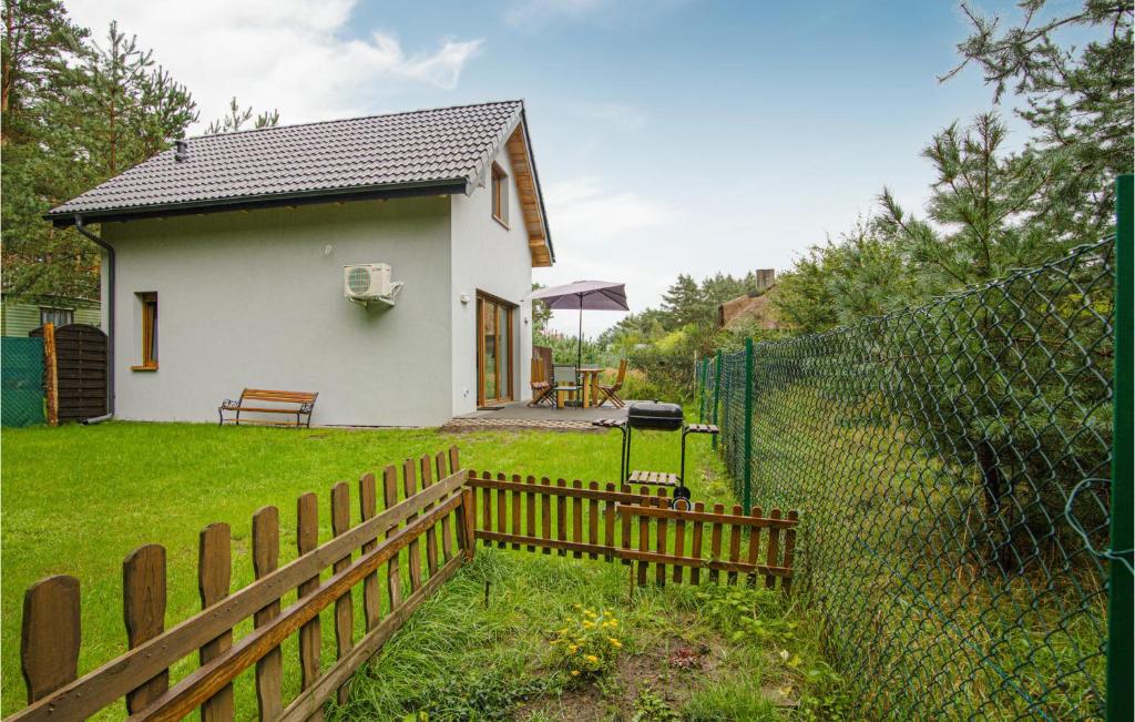 una pequeña casa blanca con una valla en el patio en 2 Bedroom Beautiful Home In Czarny Mlyn, en Czarny Młyn
