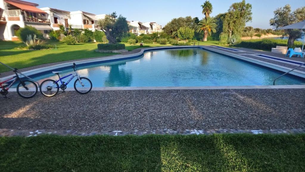 un par de bicicletas estacionadas junto a una piscina en Architect designed house with pool and private beach, en Eretria