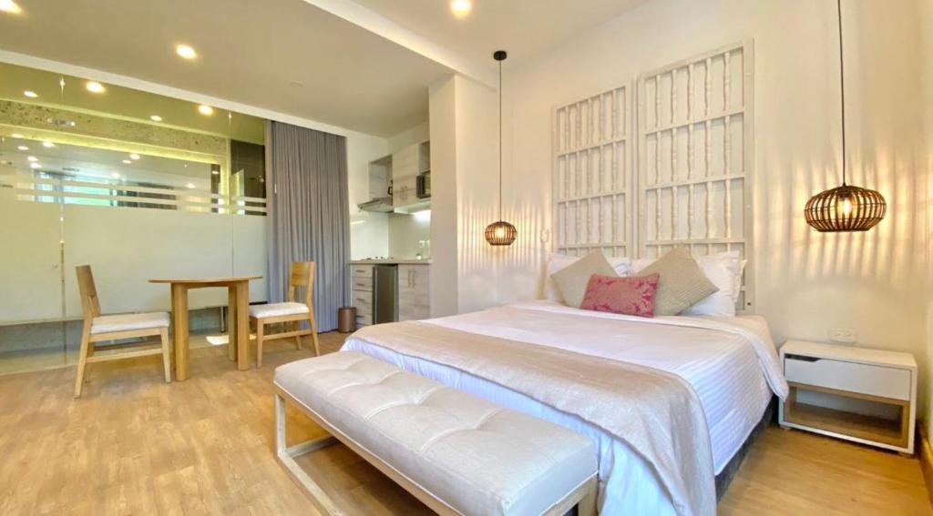 a bedroom with a large white bed and a table at Beautiful 1BR Suite 105 in Cartagena de Indias