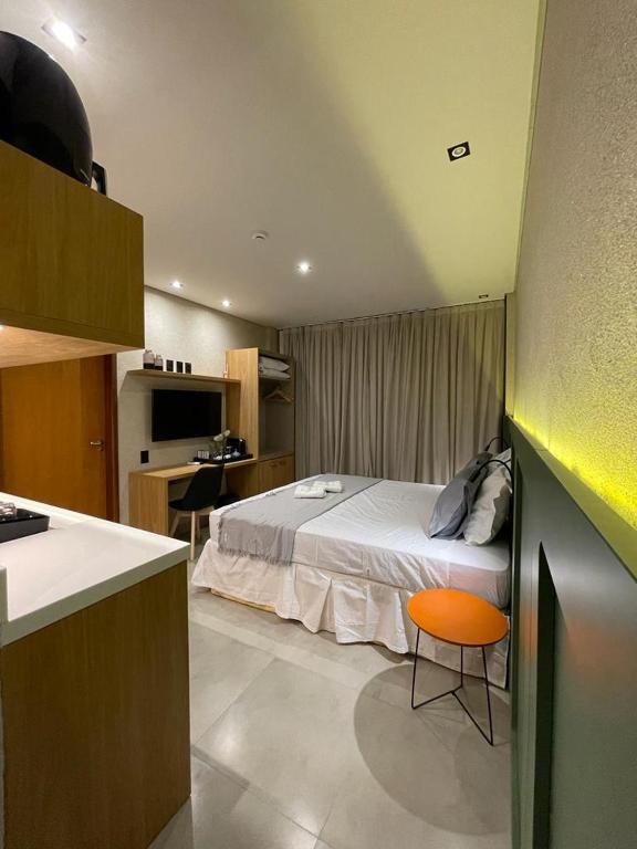 a bedroom with a bed and a desk and a kitchen at Concept Studios Barrinha in Barra Grande