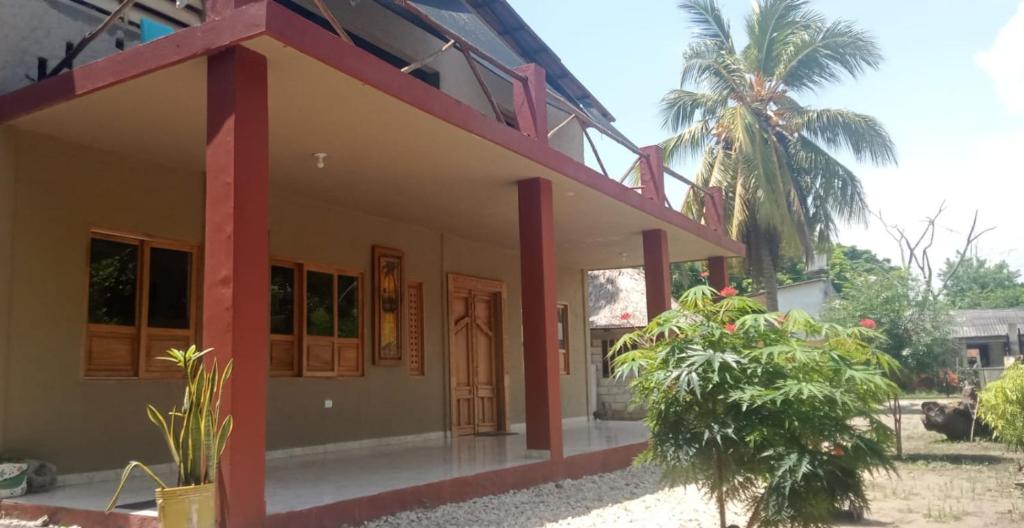 uma casa com uma palmeira em frente em CABAÑA ACUARIO em El Porvenir